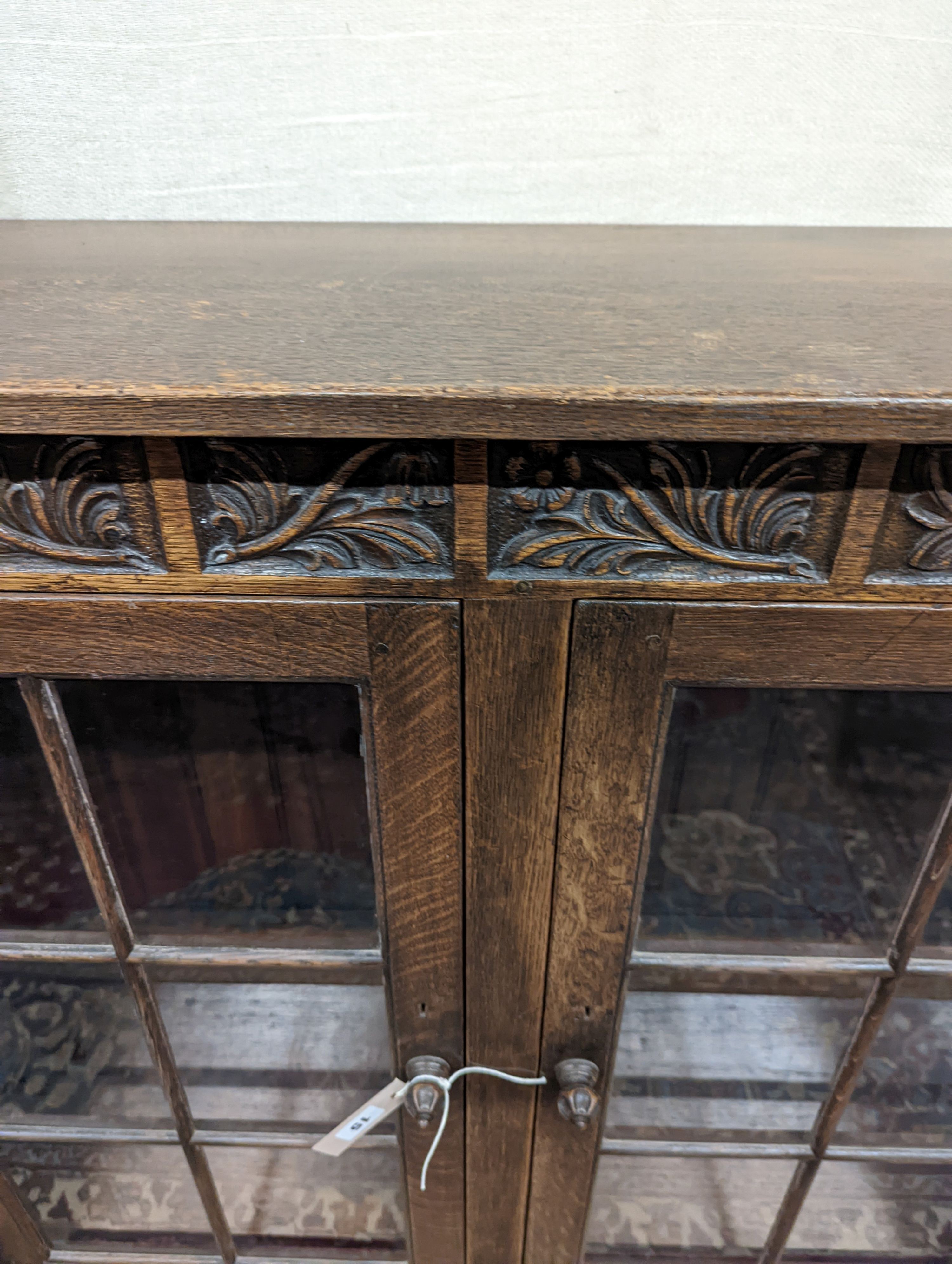 A 17th century style oak glazed low bookshelf. W-152cm, D-38cm, H-100cm.